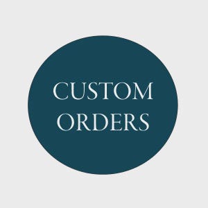 May include: A teal blue circle with the words "CUSTOM ORDERS" in white, centered. The background is a light gray.