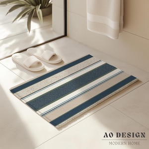 Peut inclure: Un tapis de bain rectangulaire à motifs rayés dans les tons de bleu, beige et blanc. Le tapis présente des rayures alternées de couleurs unies et de motifs texturés. Le texte "AO DESIGN MODERN HOME" est visible en bas.