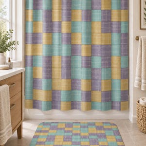 May include: A shower curtain and matching bath mat featuring a repeating grid pattern of squares in muted shades of yellow, teal, and lavender. Each square displays a subtle, fine-lined crosshatch texture throughout the fabric surface.