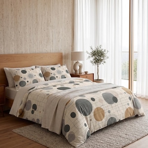 May include: A bedding set featuring a cream-coloured duvet cover and two matching pillowcases decorated with a geometric pattern of overlapping circles in shades of charcoal grey, light grey, and tan, accented by a thin black grid line design.