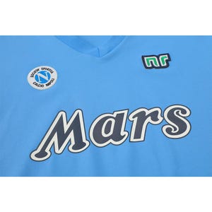 May include: Light blue v-neck jersey with the word "Mars" in large, dark blue letters with a white outline. Features a patch with the letters "nr" and a circular emblem with text "Societa Sportiva Calcio Napoli".