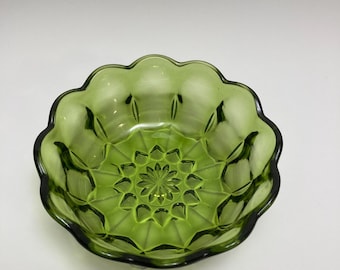 May include: A green glass bowl with a scalloped edge and a diamond pattern. The bowl is perfect for serving snacks or desserts.