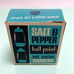 May include: Vintage salt and pepper shakers in a box. The box is teal and brown with the words "SALT & PEPPER" and "ball point" printed on the front. The box also says "self sealing SHAKERS".