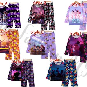 May include: Collection of pajama sets, each featuring a long-sleeved top and matching pants. Styles vary with different graphic designs, including images of people, and the text "KPOP DEMON HUNTERS". Colors include purple, orange, and blue.