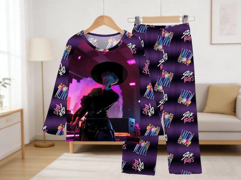 May include: Purple pajama set featuring a long-sleeved top and pants. The top displays a stage performance graphic, while the pants have a repeating pattern of a group of people and the text "Six Boys".
