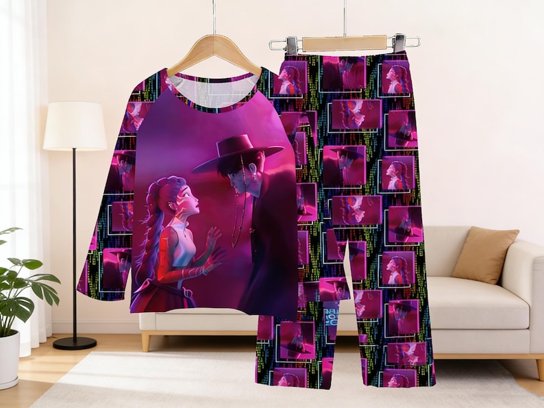 May include: A pajama set featuring a long-sleeved top and pants. The top displays a vibrant illustration of two figures in a romantic scene, while the pants are patterned with repeating images of the same figures. The color palette includes shades of pink, purple, and black.