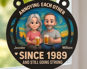 May include: A round black wooden sign with the text "ANNOYING EACH OTHER" and "SINCE 1989 AND STILL GOING STRONG". The sign features a cartoon couple holding beer mugs, with the names "Jennifer" and "William" below them.