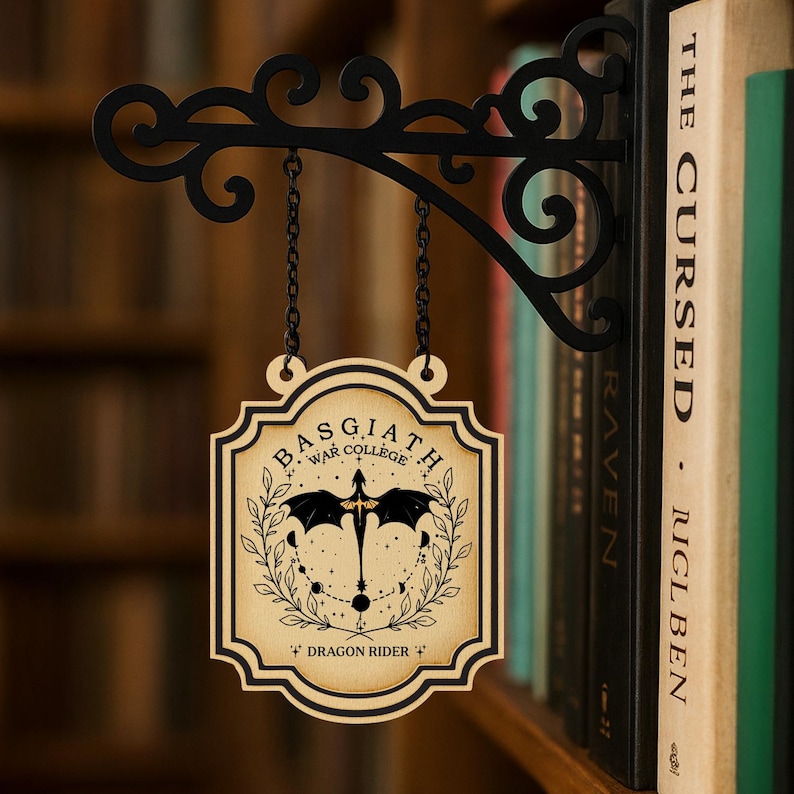 May include: A wooden sign with the text "BASGIATH WAR COLLEGE" and a dragon graphic, hanging from a black metal bracket. The sign is suspended by chains and is set against a blurred background of bookshelves.