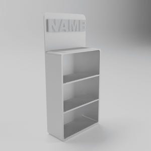 Puede incluir: Un expositor minorista blanco con tres estantes y un letrero superior que dice "NAME". El expositor tiene un diseño moderno y minimalista, ideal para exhibir productos. Los estantes tienen una textura acanalada.