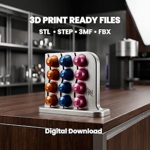 Könnte beinhalten: Ein silberfarbener Kaffeekapselhalter aus Metall mit drei vertikalen Reihen von je vier Kapseln in Orange, Blau und Pink. Der Text 3D PRINT READY FILES STL • STEP • 3MF • FBX und Digital Download ist sichtbar. Der Halter zeigt ein kleines N-Logo.