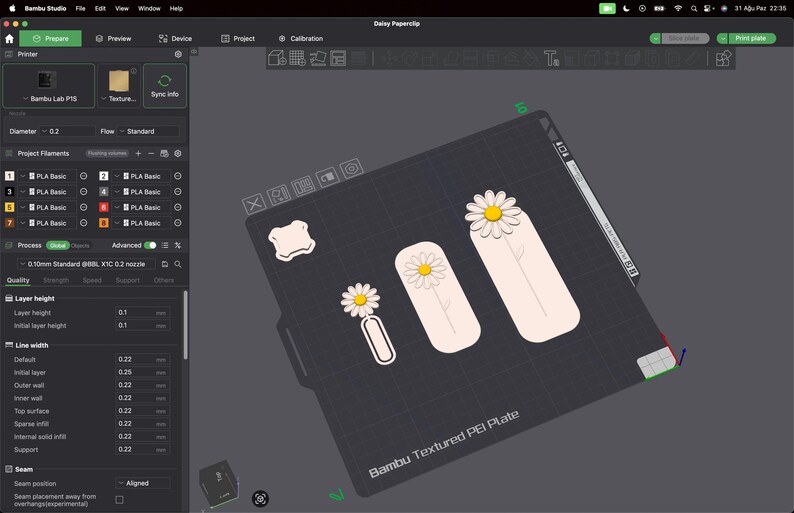 May include: A digital interface for Bambu Studio software displaying a 3D print project titled Daisy Paperslip. The screen shows a virtual build plate with three daisy-themed designs in white, yellow, and light pink, alongside printer settings.
