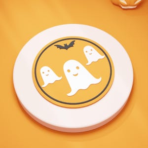 以下が含まれることがあります： 白い縁とオレンジ色の中心部を持つ、ハロウィーンをテーマにしたコースター。デザインは、3つの白い幽霊の姿と黒いコウモリのシルエットが特徴です。コースターはオレンジ色の背景に配置されています。