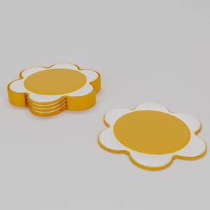 May include: A set of daisy-shaped coasters. The coasters are yellow with white petal edges and a yellow center. One stack of coasters is visible, along with a single coaster. The coasters are made of a solid material.