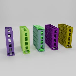 Puede incluir: Cinco contenedores de almacenamiento rectangulares de colores en morado, verde, gris, morado y amarillo. Cada contenedor tiene un diseño único con secciones recortadas y patrones perforados. Los contenedores están dispuestos en fila sobre un fondo blanco.