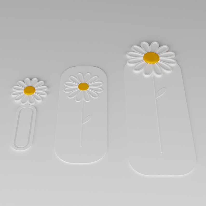 May include: Three white bookmarks of varying lengths, each featuring a raised daisy design with a yellow centre. The smallest bookmark has an open oval base, while the two larger bookmarks are solid rectangular shapes with rounded corners.