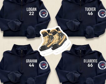 May include: Navy blue quarter-zip pullovers with white text and numbers. Each pullover has a team logo patch. The names "LOGAN", "TUCKER", "GRAHAM", and "DI LAURENTIS" are displayed with the numbers 22, 46, 44, and 66. A sticker of ice skates is in the center.