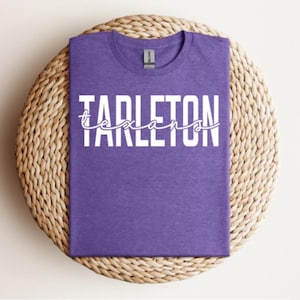 May include: Purple t-shirt with white text that reads "Tarleton Texans".