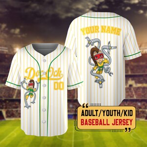 Puede incluir: Camiseta de b&eacute;isbol blanca con finas rayas amarillas, ribetes verdes y un gr&aacute;fico de dibujos animados de un personaje con brazos rob&oacute;ticos. En la parte delantera pone "Doc Ock" y "00". La parte trasera tiene "YOUR NAME". El texto en la parte inferior dice "ADULT/YOUTH/KID BASEBALL JERSEY".
