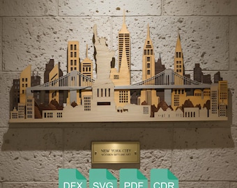 May include: Wooden New York City skyline art piece. The artwork features iconic landmarks like the Statue of Liberty and the Brooklyn Bridge, rendered in shades of light and dark wood. The piece is mounted on a textured wall.