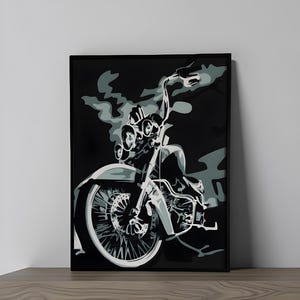 Op de afbeelding: Zwart ingelijste motorfiets kunstprint. Het kunstwerk toont een motorfiets in grijstinten en wit tegen een zwarte achtergrond. De motorfiets heeft een groot voorwiel en een gedetailleerde motor. De print wordt weergegeven op een houten oppervlak.