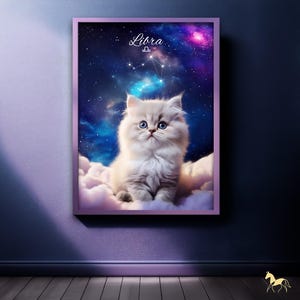May include: A framed print featuring a fluffy white cat with blue eyes, sitting on clouds against a starry galaxy backdrop. The word "Libra" and a constellation are visible at the top. The frame is a soft purple color.