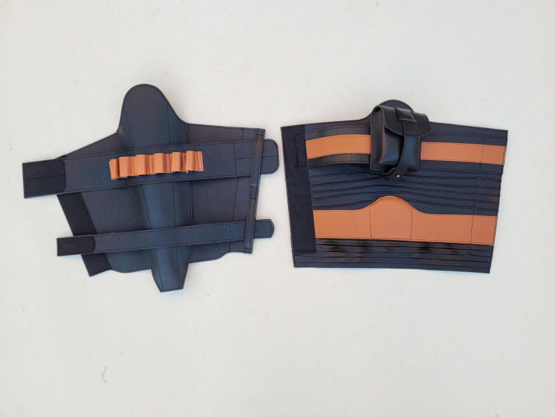 May include: Two pieces of black leather armor with brown accents. One piece has a series of brown cylindrical holders, and the other has a small black pouch. Both pieces have straps for securing.