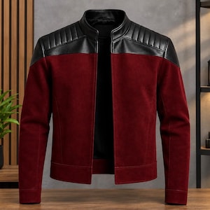 May include: A jacket featuring a deep red suede-like body and black leather-like panels on the shoulders and upper chest. The garment has a stand-up collar, long sleeves with cuffs, and a front opening with a smooth, solid-colored interior lining.