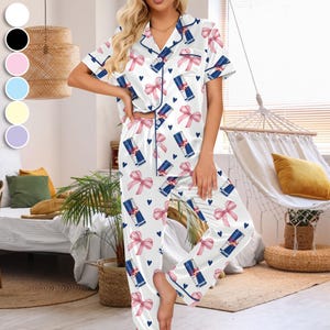 Puede incluir: Conjunto de pijama de sat&eacute;n blanco con un estampado de lazos rosas, corazones azules y latas de Red Bull. La parte superior de manga corta y los pantalones tienen ribetes azul marino. Dise&ntilde;ado para la comodidad y la relajaci&oacute;n.