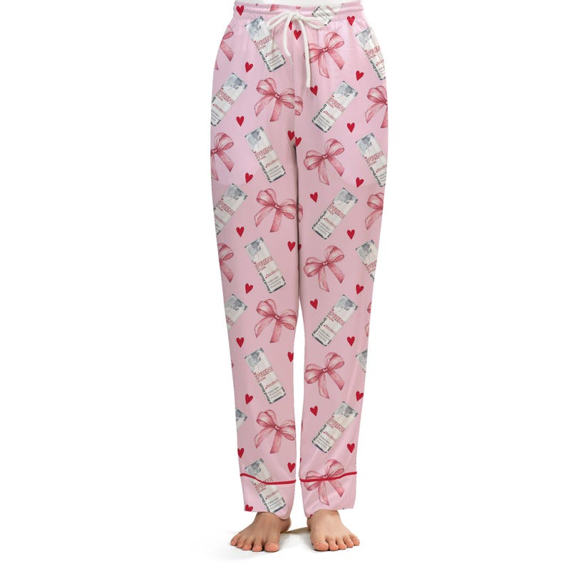 Puede incluir: Pantalones de pijama rosas con un estampado repetido de lazos rojos, cajas de regalo y corazones. Los pantalones tienen cintura con cord&oacute;n y ribete rojo en los pu&ntilde;os. Los pantalones de pijama est&aacute;n hechos de un material suave y c&oacute;modo.