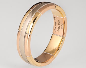 May include: A gold, silver, and rose gold band ring with a textured design. The inside of the band is engraved with "585 750 SW D. Herau".