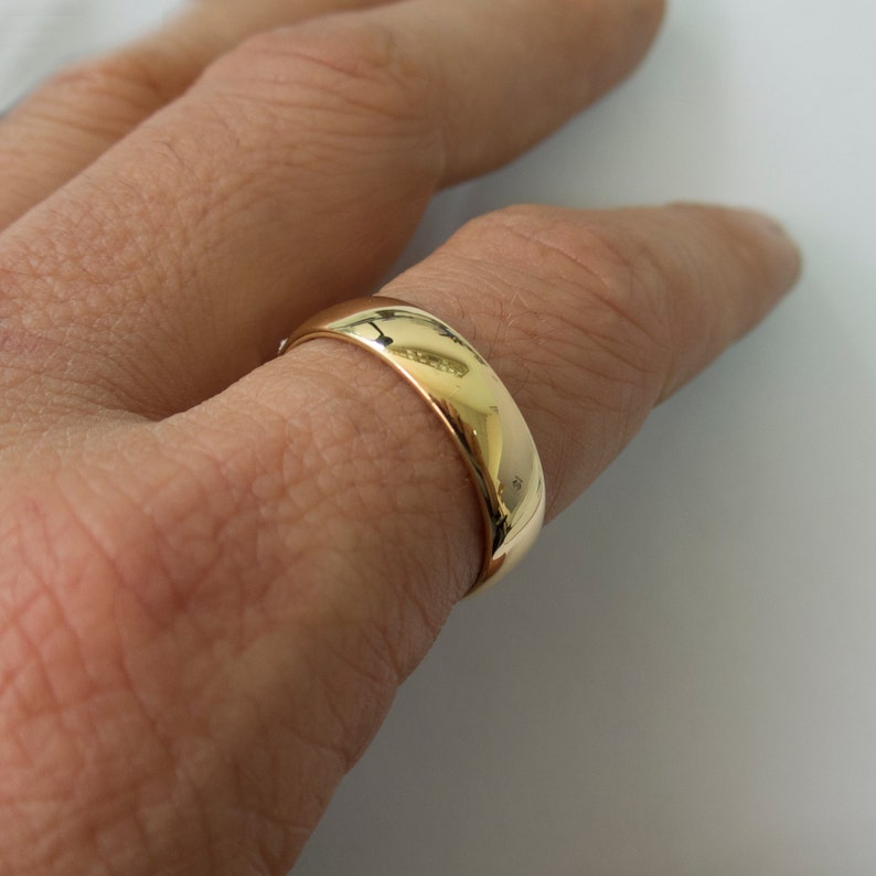 以下が含まれることがあります： 滑らかで丸みを帯びた表面を持つ金の結婚指輪