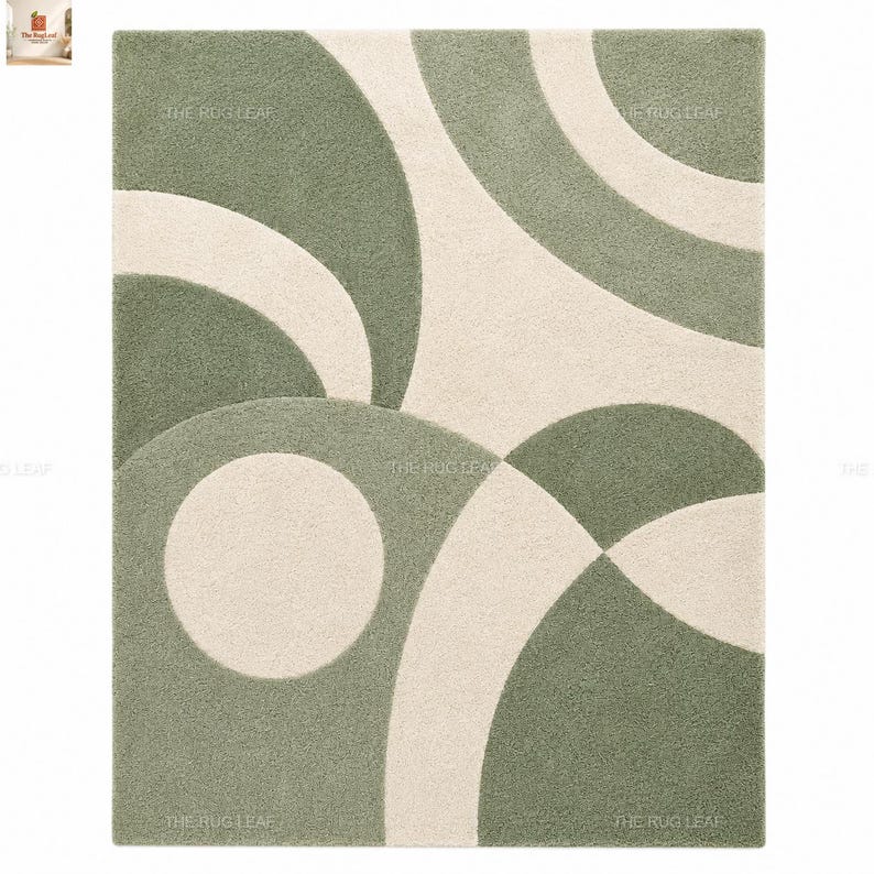 May include: A rectangular area rug featuring a high-pile texture with a geometric pattern of sage green and cream-coloured curved shapes and circles. The design consists of overlapping arcs and circular forms that create a balanced composition.