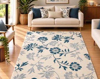 Può includere: Un tappeto rettangolare con sfondo color crema e un motivo floreale ripetuto in tonalità blu scuro e grigio chiaro. Il design è composto da fiori stilizzati e tralci di foglie distribuiti sull'intera superficie del tappeto.