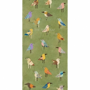 May include: A rectangular runner rug with a solid sage green background featuring a repeating pattern of small, stylized birds in various colors including yellow, blue, pink, and brown. The rug has a short fringe at the top and bottom edges.