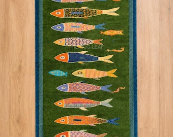 Alfombra de lana anudada a mano, con estampado de peces costeros y decoración verde.