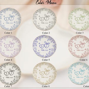 May include: A color menu displays nine decorative plates with floral designs and heart-shaped initials. Each plate features a different color scheme, including blue, green, purple, and pink. The text "Color Menu" is at the top.
