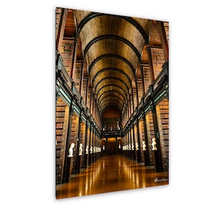 May include: A long library hall with a high, arched wooden ceiling and tall, dark wood bookshelves lining both sides. Rows of white marble busts are placed on pedestals along the aisles, reflecting on the polished, light-brown wooden floor.