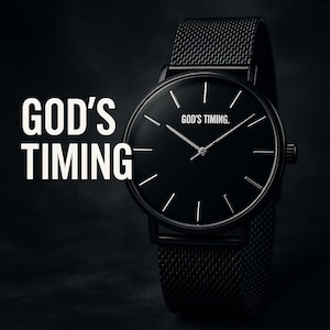 May include: A black wristwatch with a mesh band. The watch face is black with silver hands and markers. The text "GOD'S TIMING" is displayed on the left and on the watch face.