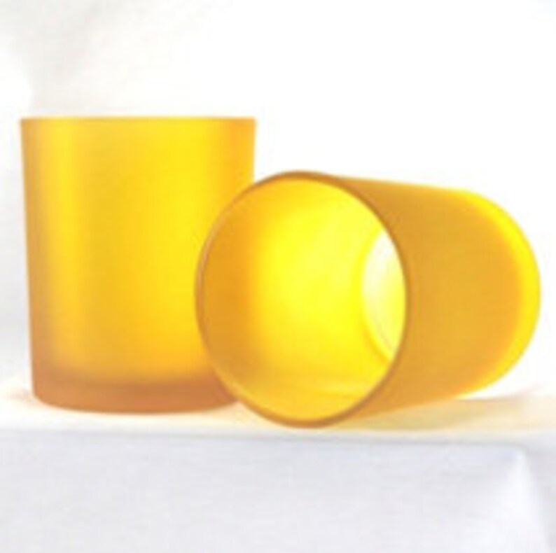 May include: Two frosted yellow glass candle jars. The jars are cylindrical and have a smooth, matte finish.