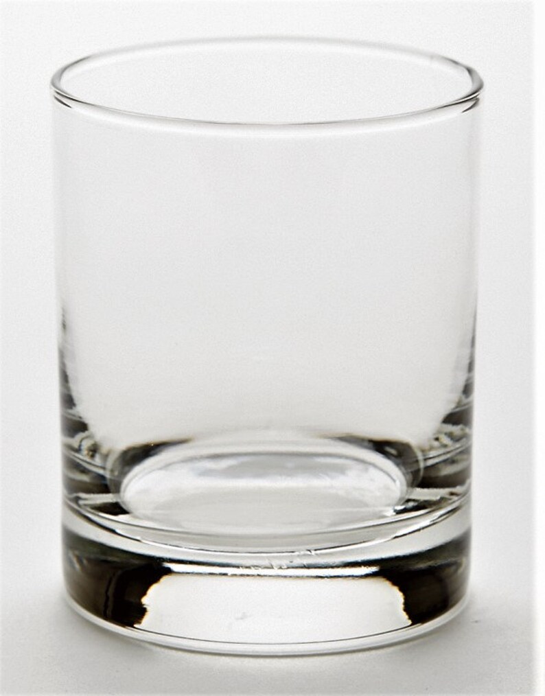 May include: A clear glass tumbler with a thick base. The glass is empty and has a smooth, rounded shape.