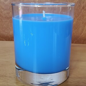 May include: A blue candle in a clear glass jar with a white wick.