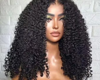 May include: A black curly wig with a natural hairline. The wig has tight, voluminous curls and is styled to frame the face. The hair is a deep black colour, and the wig appears to be made of synthetic or human hair.