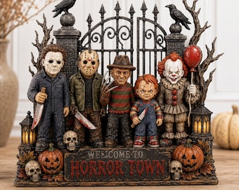 May include: A decorative horror-themed figurine featuring five iconic movie characters standing before a black iron gate. A sign at the base reads WELCOME TO HORROR TOWN. The scene includes two black ravens, three skulls, two jack-o'-lanterns, and bare tree branches.