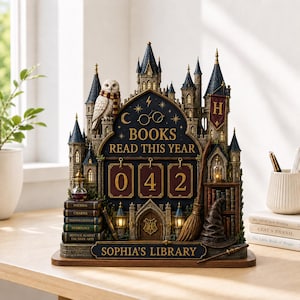 May include: A decorative tabletop display shaped like a castle, featuring a white owl, a broomstick, and a sorting hat. The center displays the text 'BOOKS READ THIS YEAR' above a counter showing '042'. A plaque at the base reads 'SOPHIA'S LIBRARY'.