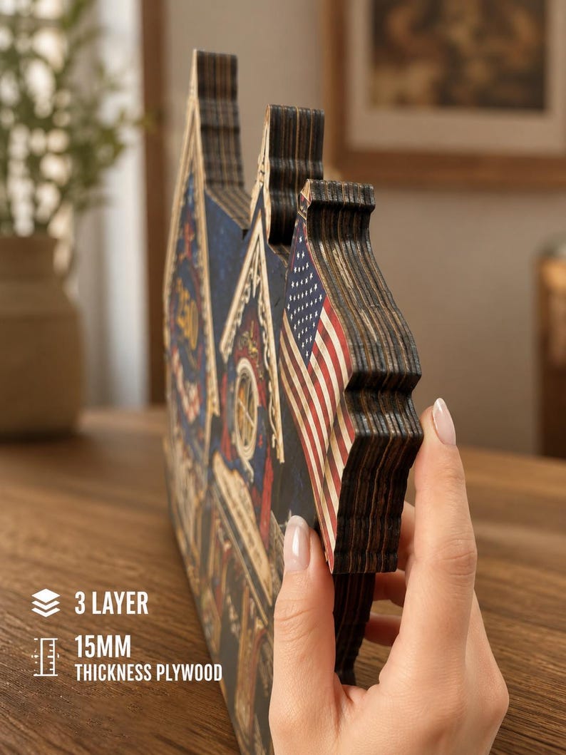 May include: A three-layer plywood decorative sign with a 15mm thickness, featuring a printed American flag and architectural details. The object is constructed from stacked wood layers, showing a side profile with visible dark edges and textures.