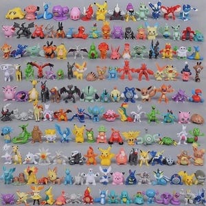 May include: A collection of colorful, small figurines of various Pokémon characters. The figures are in different poses and colors, including yellow, blue, red, and green. The collection is arranged on a gray surface.