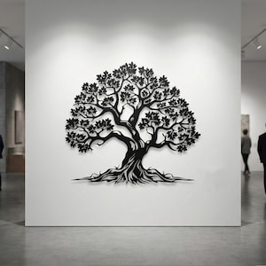 Puede incluir: Una obra de arte mural de metal negro que representa un árbol. El árbol presenta un tronco, ramas, hojas y raíces detallados. La obra de arte está montada en una pared blanca en un entorno de galería. El diseño del árbol es intrincado y artístico.