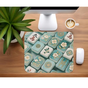 May include: A rectangular mousepad featuring a pattern of light blue and white mahjong tiles. The tiles display various floral and geometric designs, along with Chinese characters in black. A cup of coffee and a white mouse are also visible.