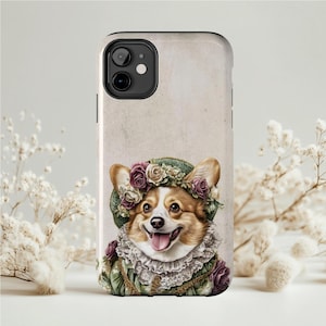 May include: A phone case with a corgi illustration wearing a floral hat and a ruffled collar. The corgi has a happy expression. The case has a light beige background and is decorated with a floral design.