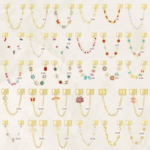 Puede incluir: Una colecci&oacute;n de cadenas de joyer&iacute;a doradas con varios elementos decorativos. Los dise&ntilde;os incluyen mariposas, corazones, estrellas, flores y piedras preciosas. Cada cadena est&aacute; conectada a un cierre rectangular.